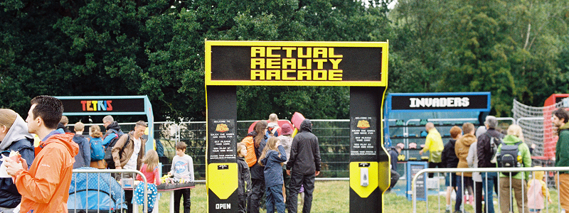 Outdoor festival entrance gate with crowds and signage
